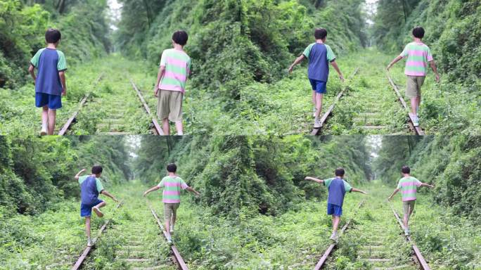男孩走在铁轨上长满杂草的废旧铁轨两个小男