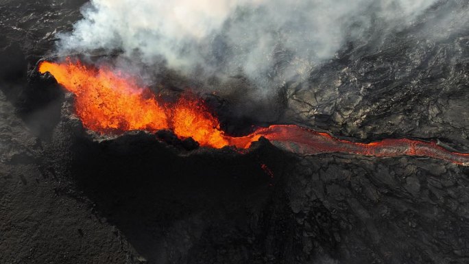 火山喷发，炽热炽热的熔岩从地面喷出，活火山火山口鸟瞰图