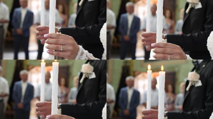 在教堂举行的婚礼上，新娘和新郎手持燃烧的蜡烛。教堂婚礼传统。