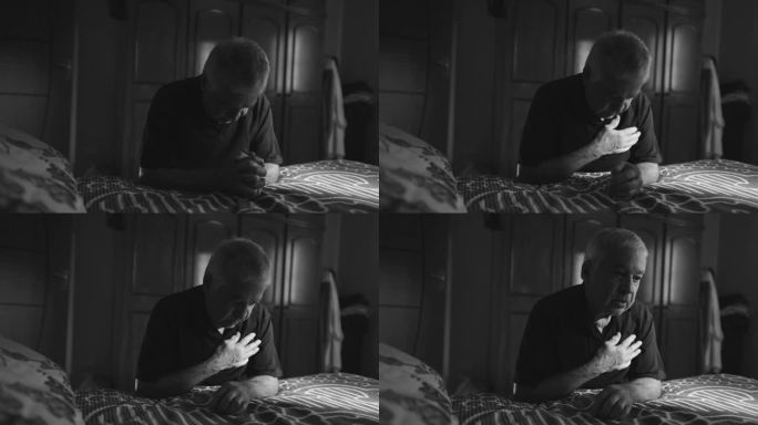 戏剧性的老人跪在床边祈祷，用信仰和希望在黑白单色中敬拜上帝