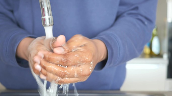 年轻人用肥皂和温水洗手