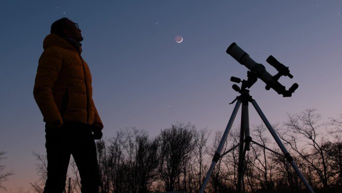 用望远镜观察星空、行星、流星雨和月食的天文学家。