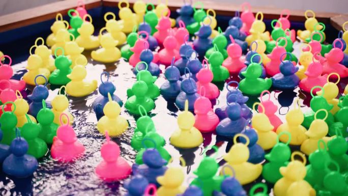 五颜六色的塑料鸭子在游戏池里游泳。背景视频。
