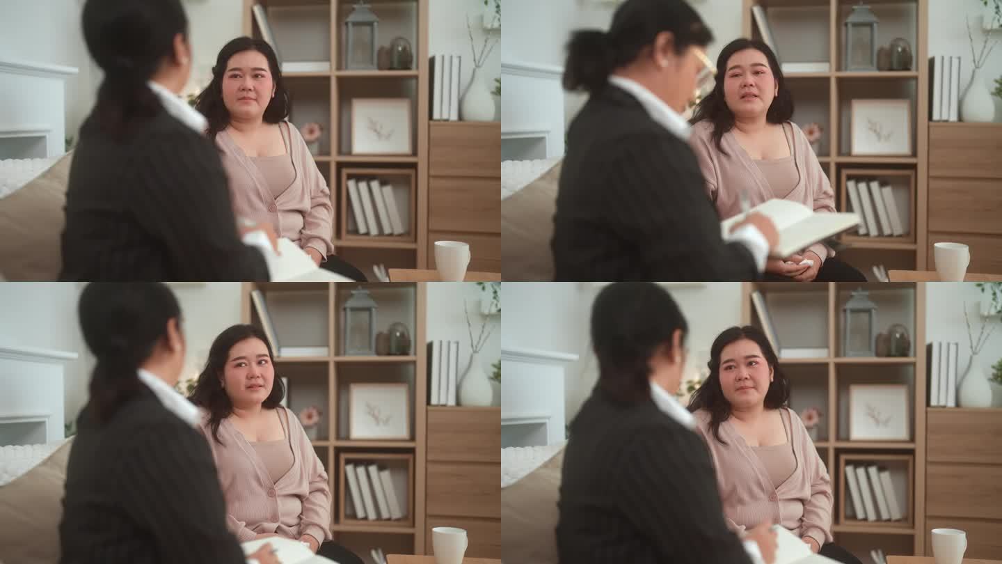 一名亚洲成年妇女在治疗过程中与她的肥胖病人交谈，跟踪她的症状。