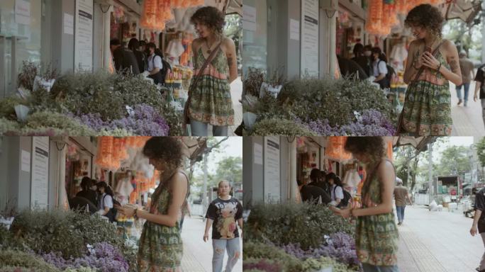 在曼谷的花卉市场，一位女游客在花店散步，与鲜花合影留念