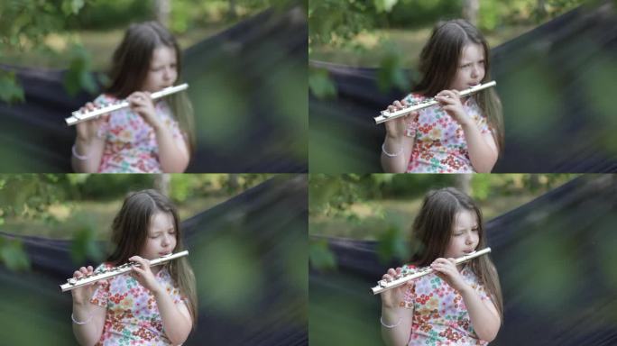 小女孩在吊床上演奏横笛