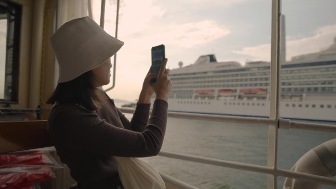 她乘坐渡轮从香港到九龙，经济而美丽的旅程。
