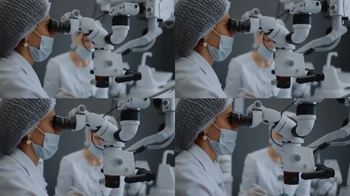 女牙医在检查或治疗病人时看手术显微镜