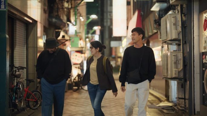 一群亚洲游客朋友走在东京的街道上，探索这个小镇。