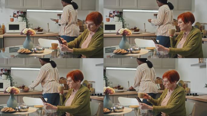 老年妇女拿着智能手机喝茶