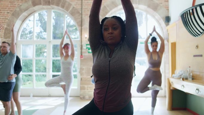瑜伽，伸展和健康与黑人女性在课堂上学习，健身和正念。平衡，冥想和和平与人和锻炼普拉提工作室教练，能量