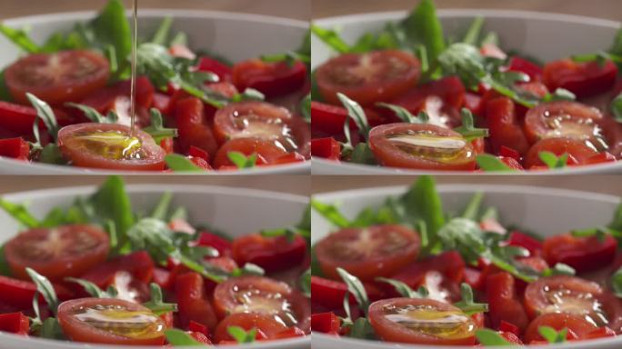 用橄榄油调味的慢镜头，配上芝麻菜、圣女果和红辣椒的新鲜沙拉特写