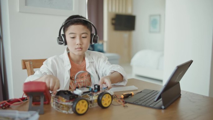 男孩在网络实验室里玩和驾驶他的机器人汽车。干教育