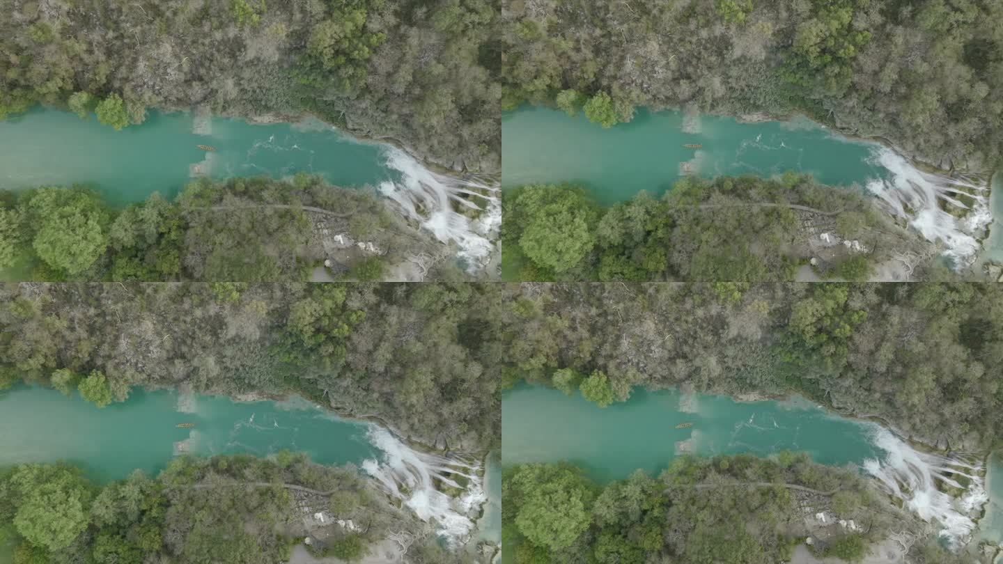 空中无人机观看瀑布和流经茂密丛林的河流