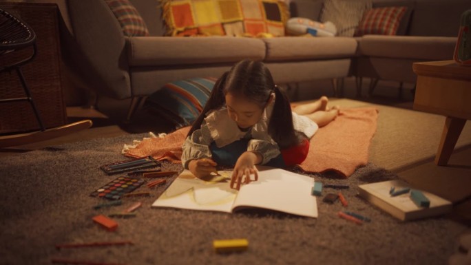 可爱小女孩躺在客厅地板上画的晚照。才华横溢的韩国孩子正在创造，上色，准备成为著名的艺术家。电影缩放多