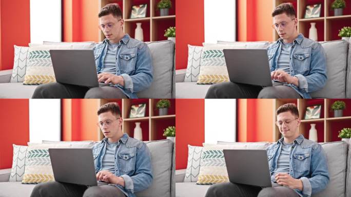 年轻的西班牙裔男子坐在沙发上使用笔记本电脑，神情紧张