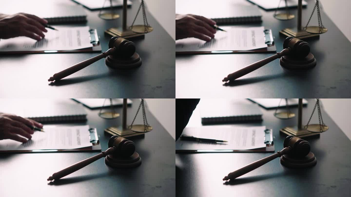年轻的律师在办公室，商人和律师在办公室的木桌上用黄铜秤讨论合同文件。法律，法律服务，咨询，司法和房地
