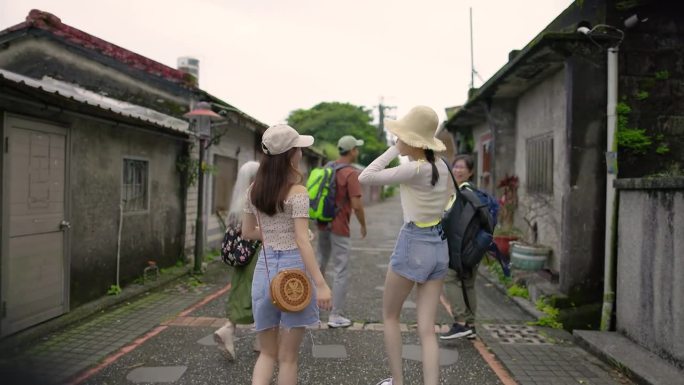 一群朋友走在传统的城镇街道上