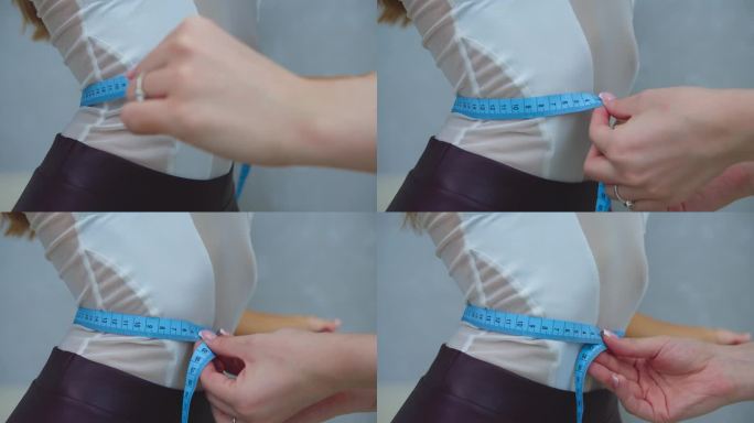 测量一个瘦小的年轻女模特的腰围