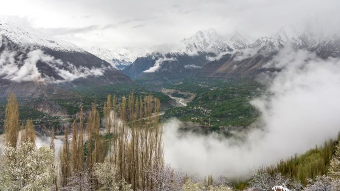 在巴基斯坦罕萨山谷的春天，喀喇昆仑山脉的雪山的雄伟景色的延时移动云雾日出场景