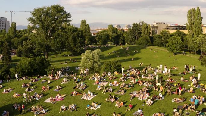 一群人在炎热的夏天晚上在公园的草地上度过了美好的时光