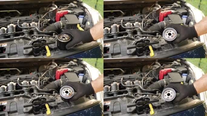 用新的机油滤清器替换旧的堵塞的机油滤清器。汽车修理和保养。
