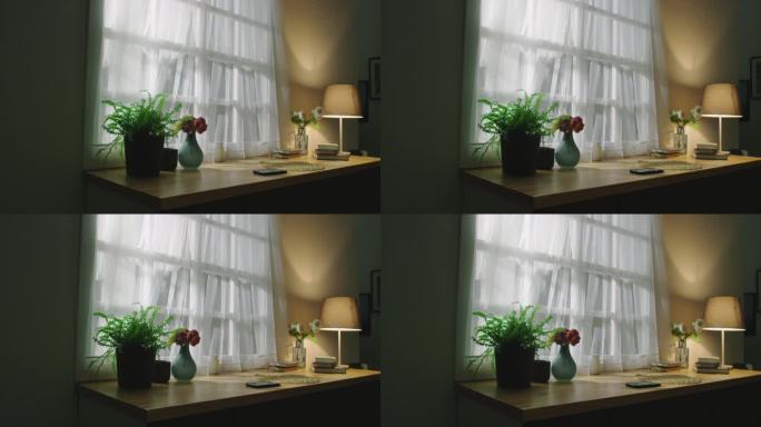 室内与桌子与花瓶的鲜花，植物，书籍旁边的窗口