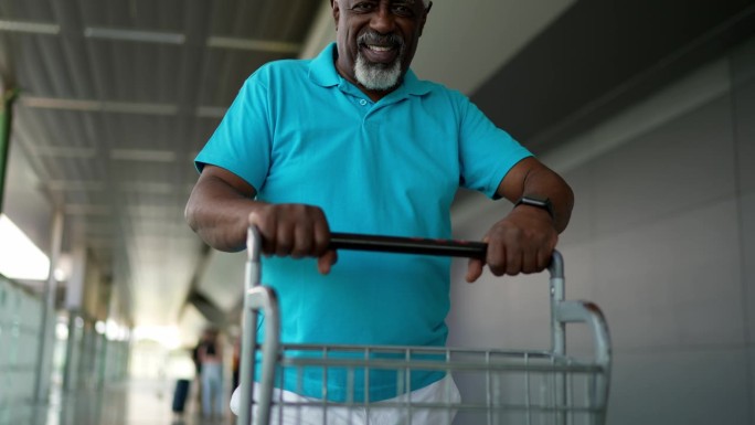 机场一位老人推着行李车的照片