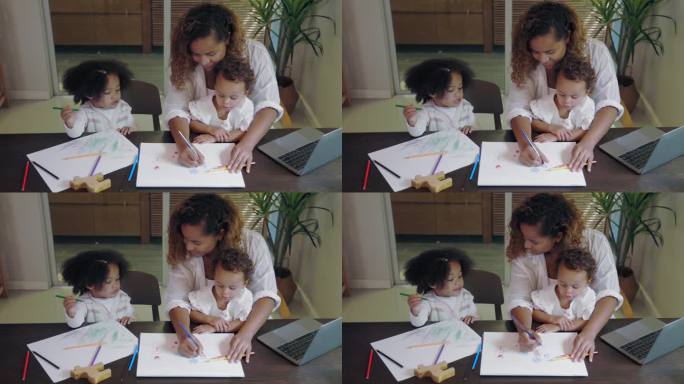 非洲母亲一边在家工作一边和孩子画画
