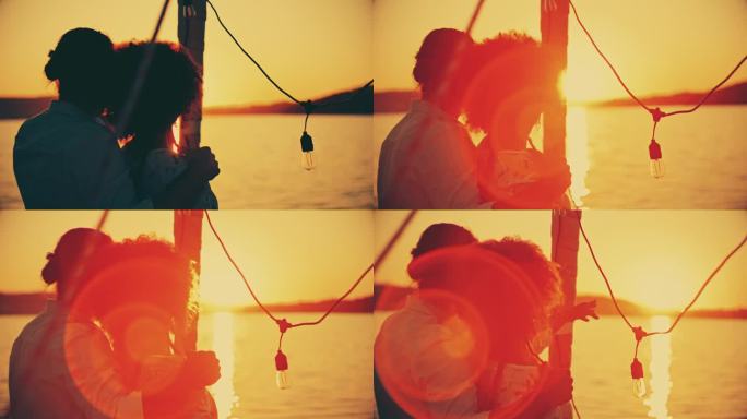 日落时分，一对夫妇在船上欣赏海景的剪影