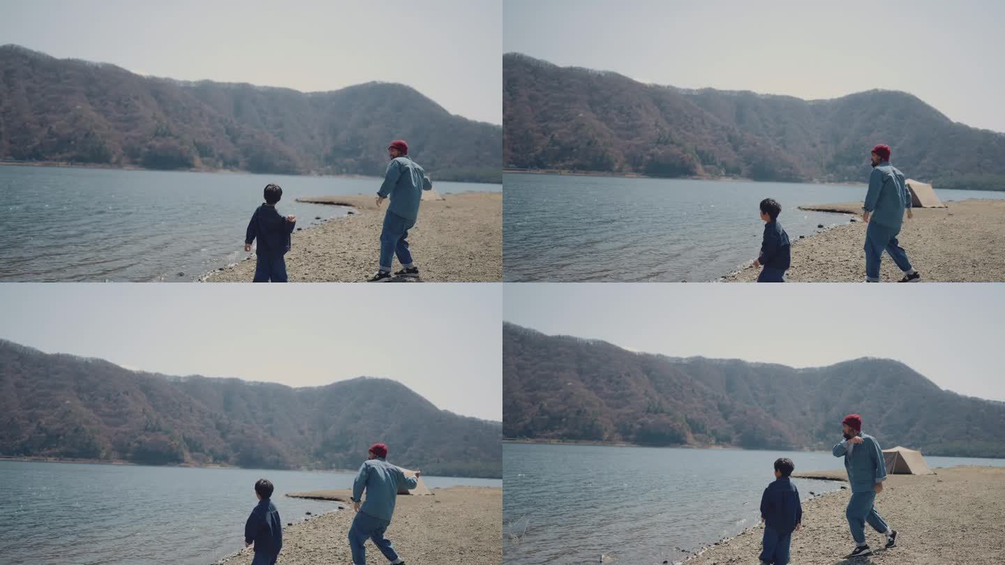 亚洲父亲和儿子一起去大自然度假时，在湖里玩耍和扔石头。