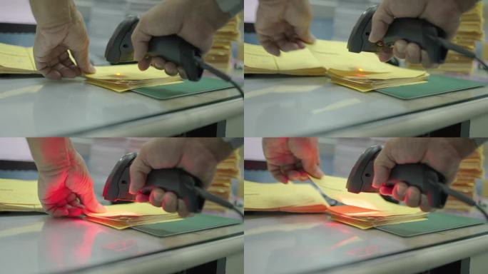 近距离人手用条码扫描器扫描黄色明信片上的条码，将数据信息转换成数字计算机。