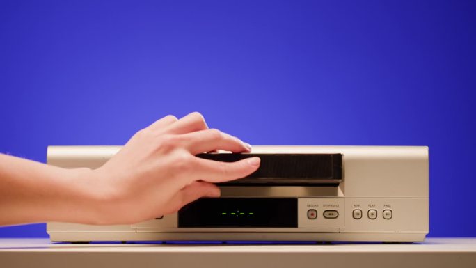 旧录像机的特写，VHS。复古播放器，老式录像带广播在蓝色背景，音频磁带。