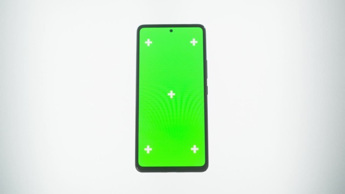 一个智能手机与模拟绿色屏幕Chromakey显示与运动跟踪占位符的自上而下的视图。在白色背景下放大手