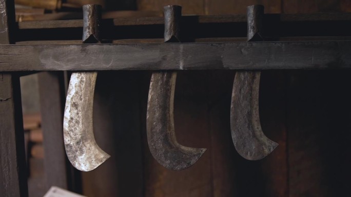 古色古香的铁刀插在老木屋的木墙里。