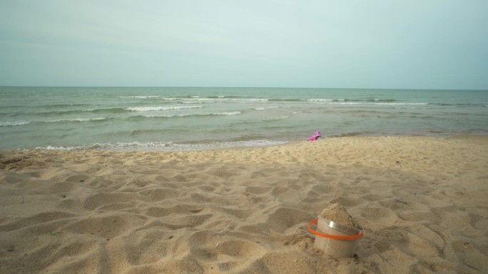 快乐的海滩游戏:无忧无虑的孩子在阳光明媚的海岸线上堆沙堡