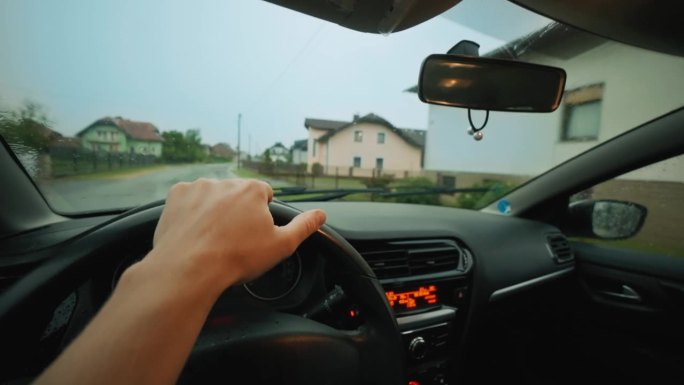 多雨的道路。手放在方向盘上。挡风玻璃的观点。准备好在雨季来一场惊心动魄的POV公路之旅吧