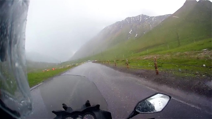 摩托车在暴雨暴雨中骑行山路，水湿骑手，乔治亚旅行pov