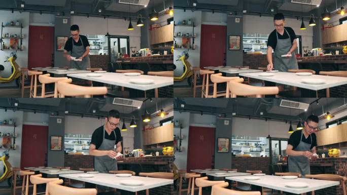 一位亚洲男性餐厅老板在开业前精心准备餐具。