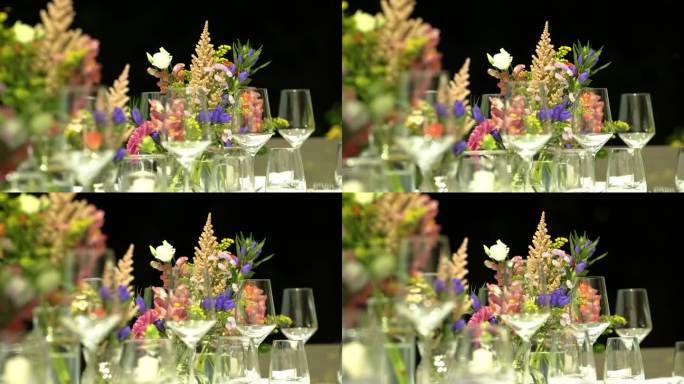 桌子上摆放着空酒杯和自然花园颜色的花朵
