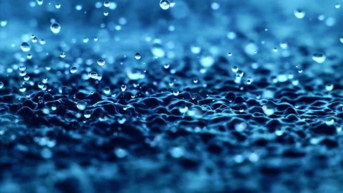 微距特写超慢动作1000fps。飞溅的液体呈蓝色。当地表水振动时溅水滴液。波浪和蓝色背景滴。抽象晶体