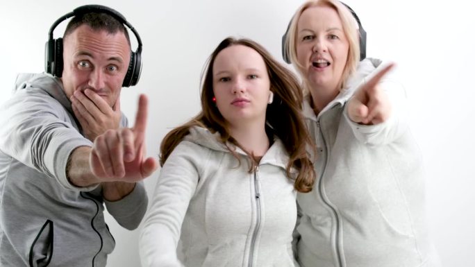 一个男人和两个女人十几岁的女孩用食指做消极的摇摆不，不要这样做，看着画面伸出手指向前耳机运动服白色背