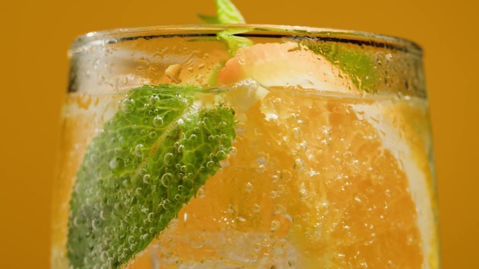 橘子柠檬汁在橙色的背景。水果柑橘味的鸡尾酒特写质感，健康甜饮。排毒饮酒，夏日提神概念。
