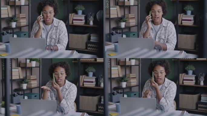 年轻的非裔美国女性自由职业者在家庭办公室用手机和笔记本电脑与客户交谈
