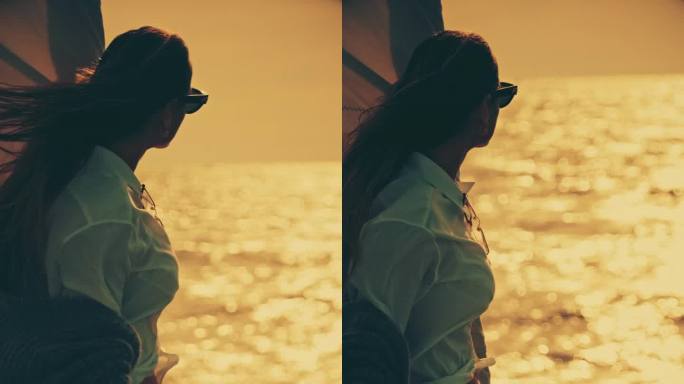 夕阳下，年轻女子站在帆船甲板上望着大海