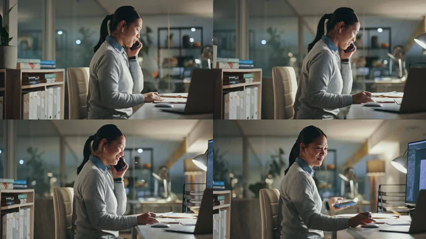 晚上，与亚洲女商务人士电话咨询，与企业行政部门联系并交谈。智能手机通讯，讨论和日本工人查看笔记本电脑
