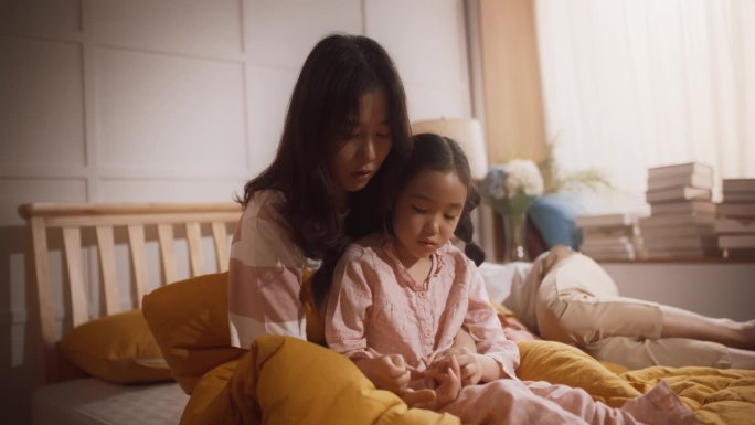 韩国母亲和女儿在一起度过一个宁静的早晨，交谈和亲密。深情的亚洲女人与她的孩子沟通，用无条件的爱保持养