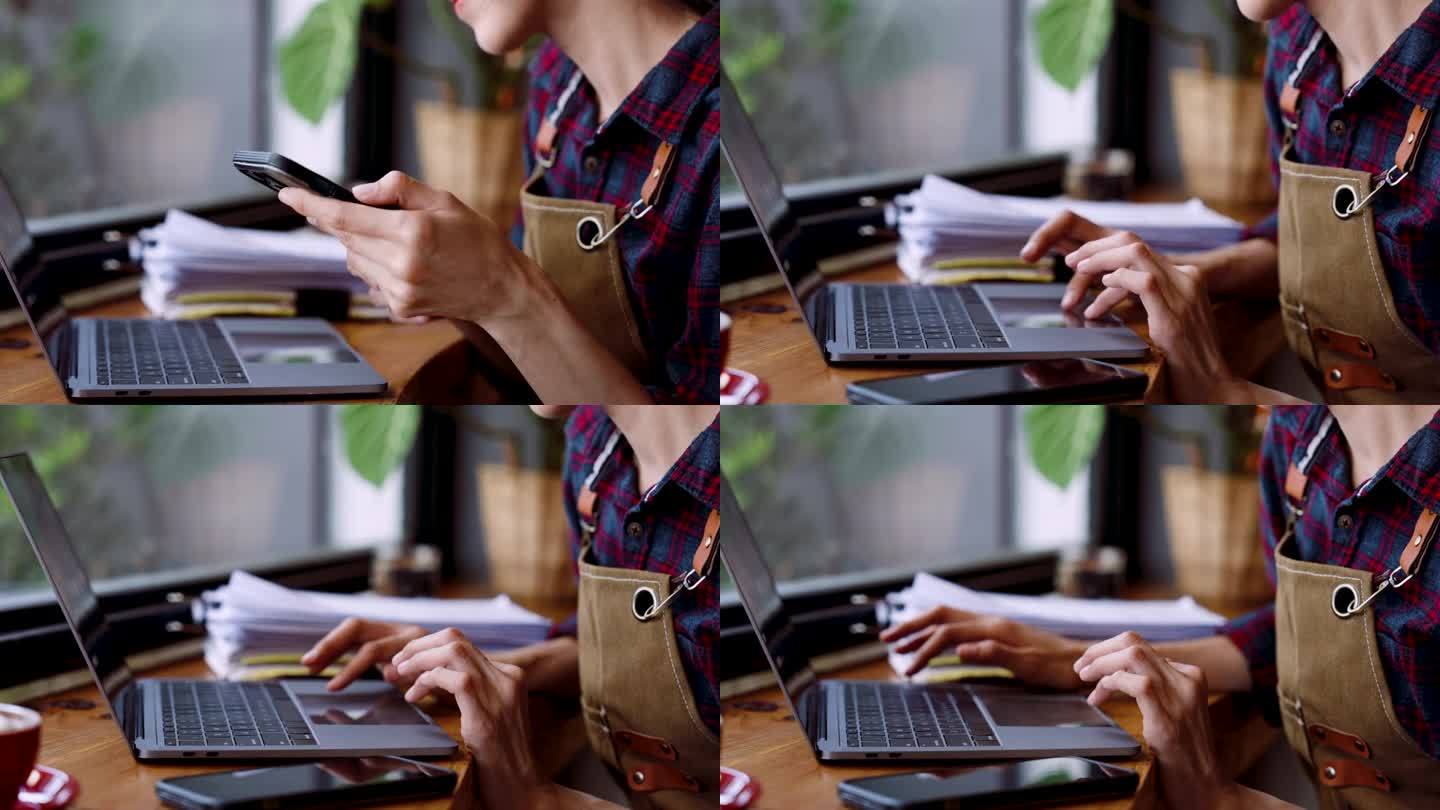特写手握手机收屏锁放在桌上，然后把手放在笔记本电脑的键盘上，在笔记本电脑上打字，收屏前查看咖啡馆的收