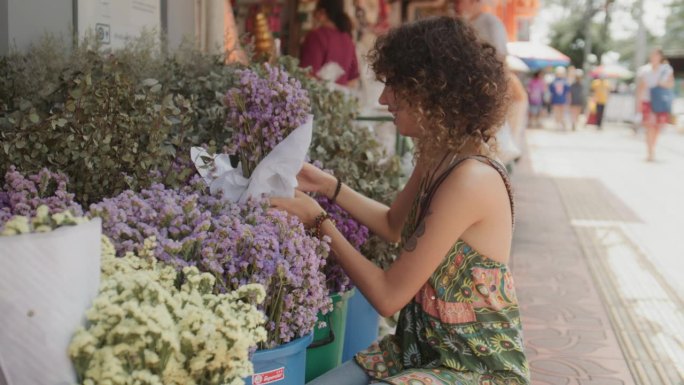 一名女游客在曼谷度假时，在鲜花市场欣赏鲜花时被迷住了。