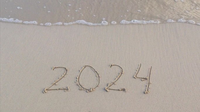 数字2024写在海边的沙滩上。